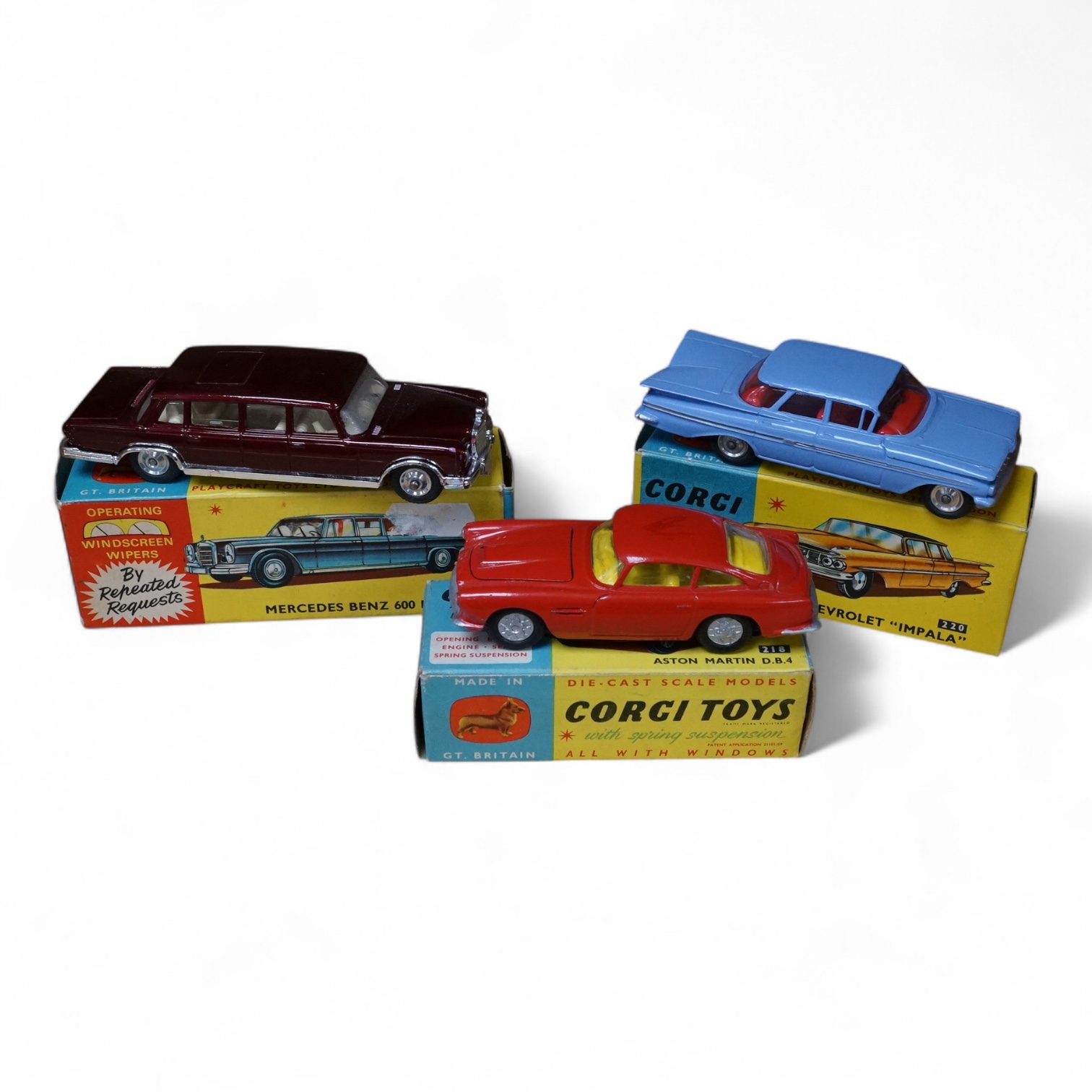 Three boxed Corgi Toys; a Mercedes-Benz 600 Pullman (247) in metallic maroon, a Chevrolet Impala (220), in sky blue with red interior, and an Aston Martin DB4 (218) in red with yellow interior. Condition - good, some dam